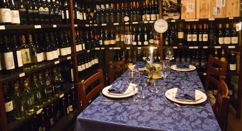 Un tavolo incorniciato da bottiglie di vino locale al ristorante Franco Rossi di Bologna - Fonte: Quandoo